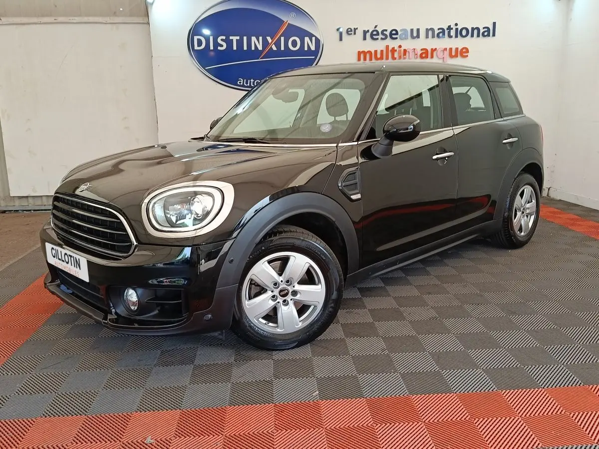 MINI Countryman Cooper noir en 3/4 avant droit, avec phares LED et jantes alliage visibles en intérieur showroom.