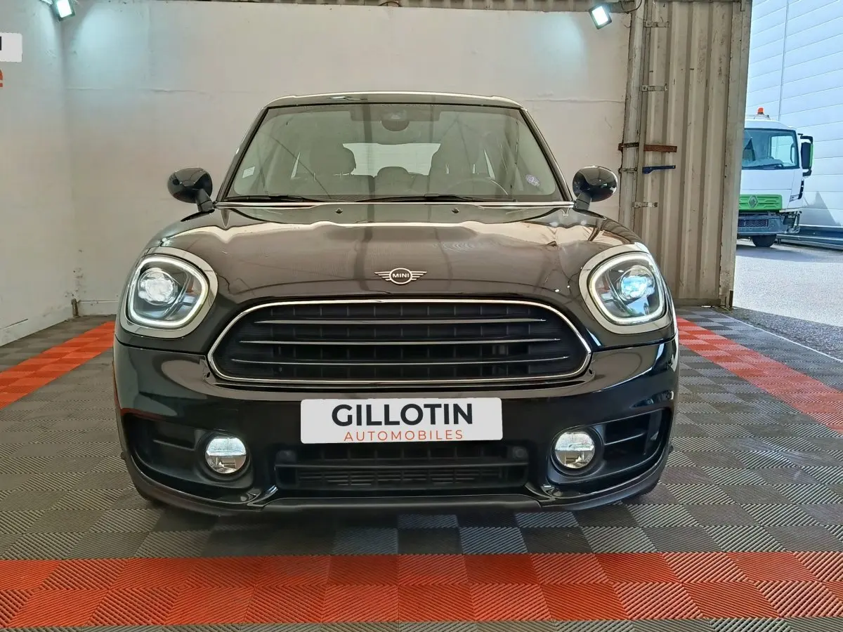 Vue frontale d’un MINI Countryman noir 2019 avec phares LED et calandre noire brillante dans un garage.