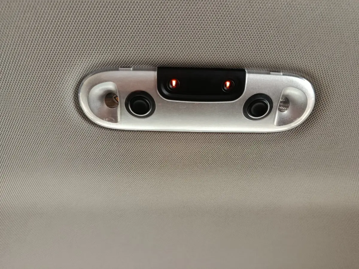 Plafonnier intérieur gris avec deux petites lampes rouges allumées sur une MINI Countryman noire, vue en gros plan.