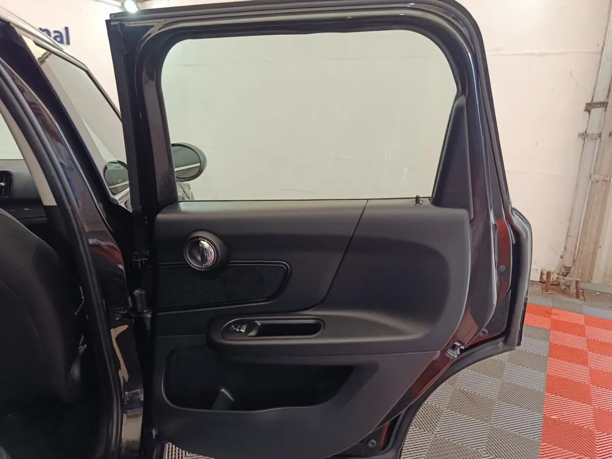 Vue rapprochée de la porte arrière gauche noire ouverte d'une MINI Countryman 2019, intérieur sobre et moderne.