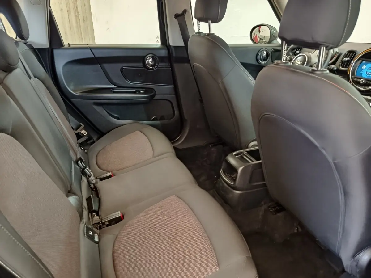 Vue intérieure arrière côté gauche du MINI Countryman 2019, sièges tissu noir et console centrale visible.