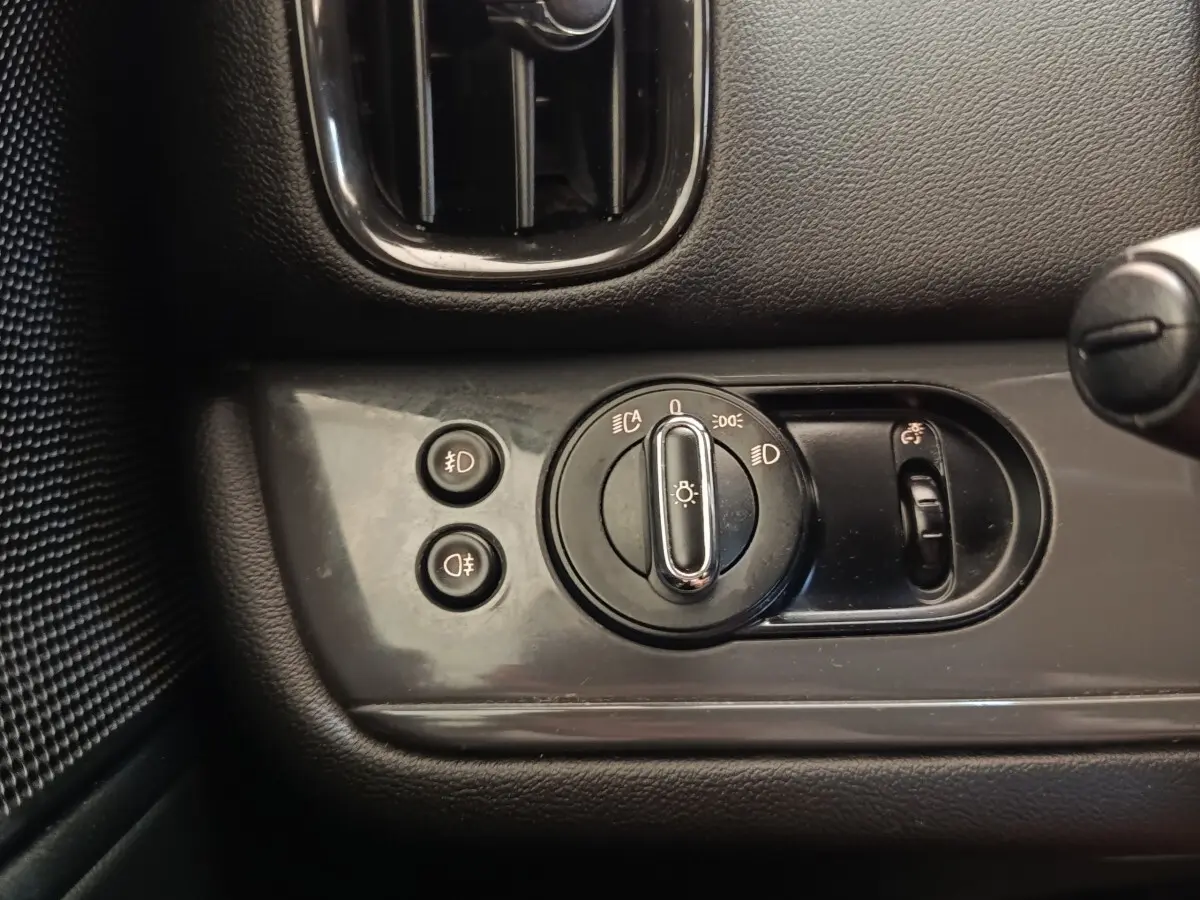 Gros plan sur le panneau de commande des phares et antibrouillards intérieur noir du MINI Countryman 2019.