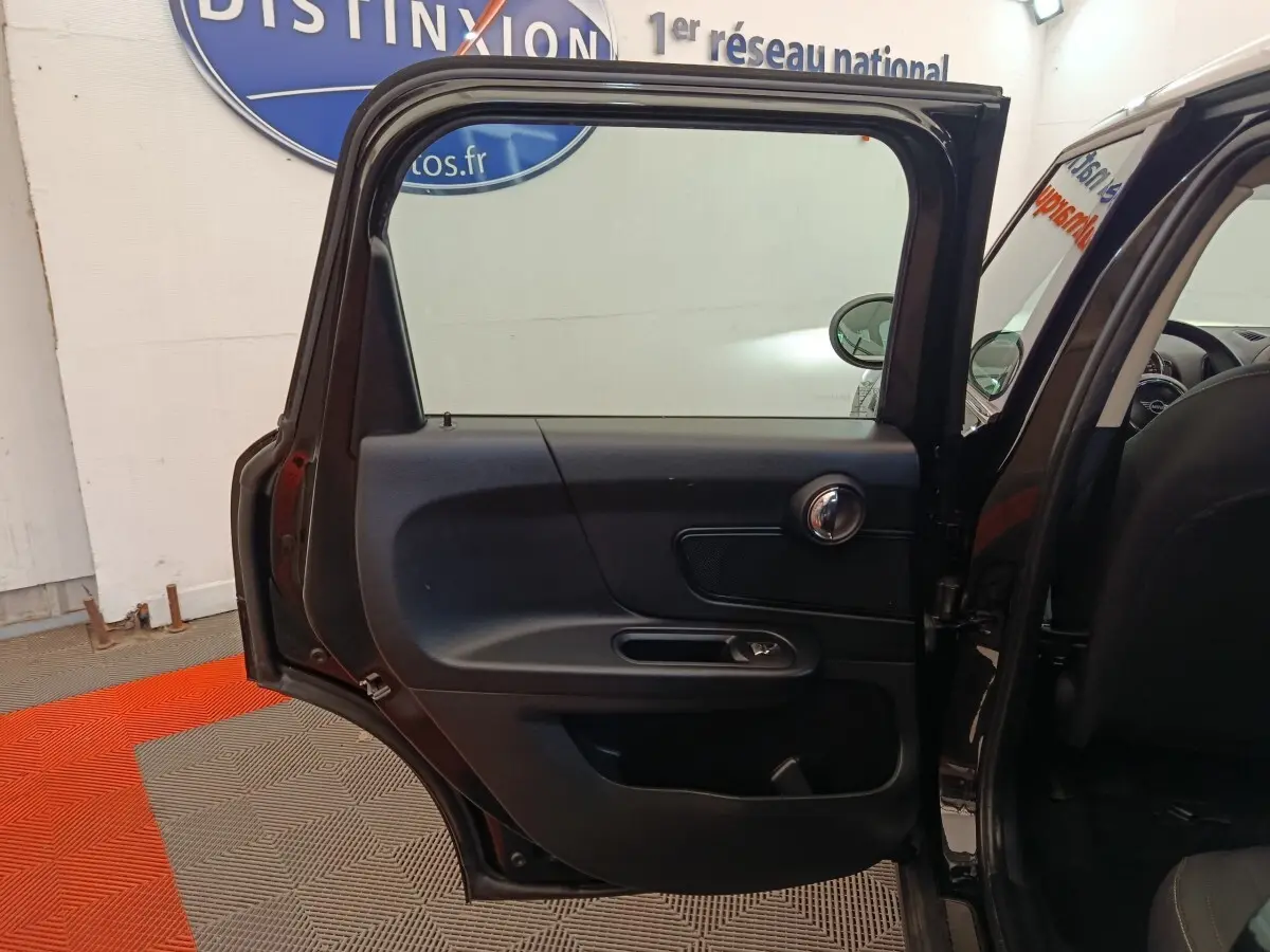 Vue intérieure de la porte arrière gauche noire ouverte d'une MINI Countryman 2019 dans un showroom.