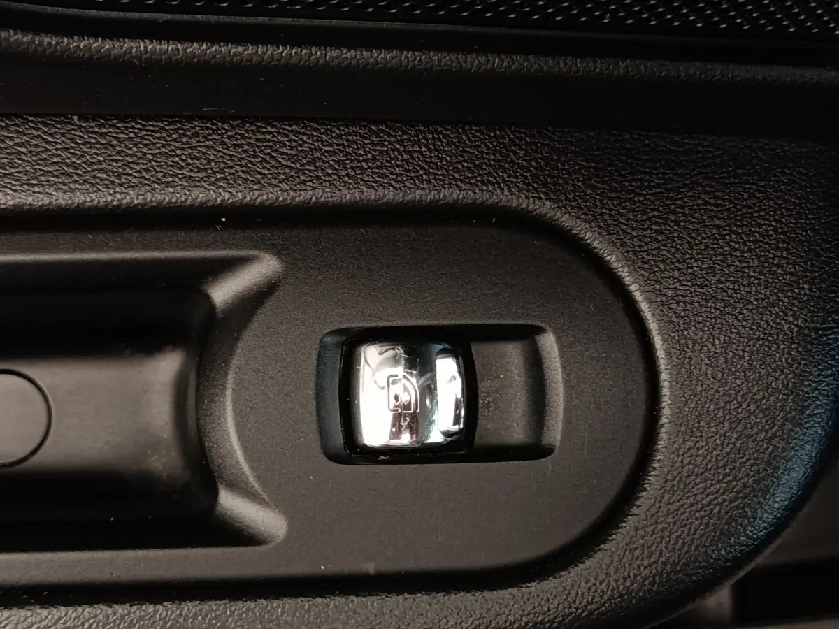 Gros plan sur le bouton d'ouverture électrique du coffre dans l'habitacle noir d'une MINI Countryman 2019.