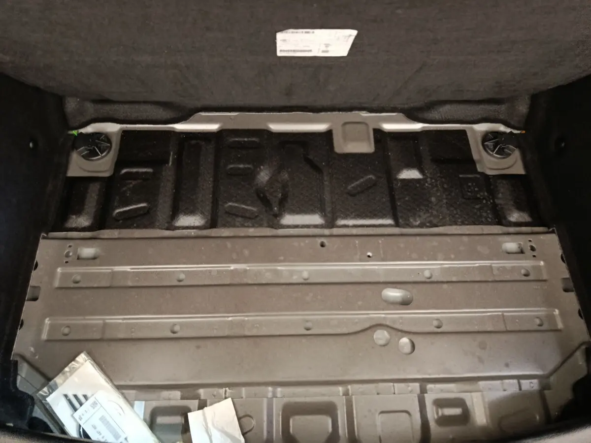 Vue rapprochée de la structure métallique du coffre arrière d’une MINI Countryman noire, sans la moquette.
