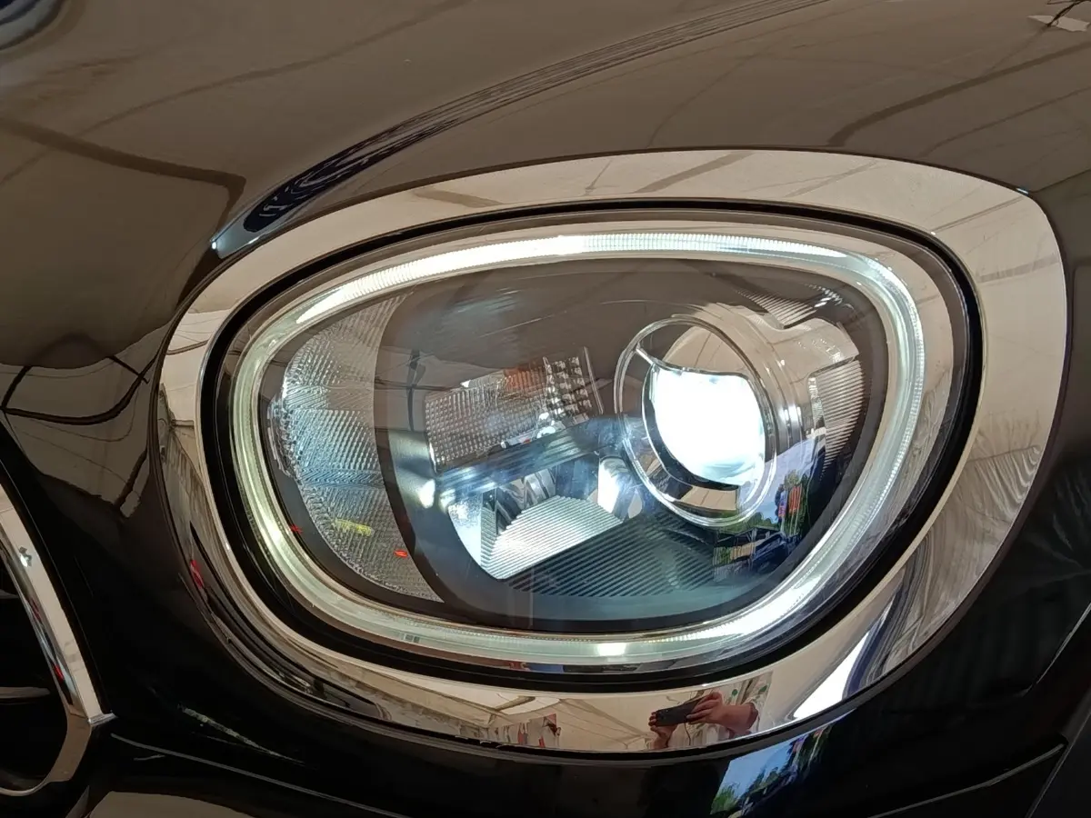 Gros plan sur le phare avant droit LED du MINI Countryman Cooper noir, soulignant son design moderne et lumineux.
