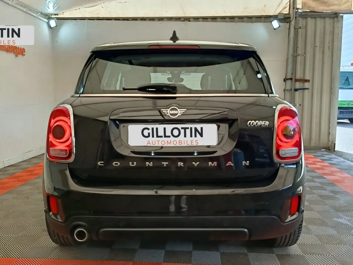Vue arrière d'une MINI Countryman Cooper noire, avec feux arrière LED et logo distinctif visible.