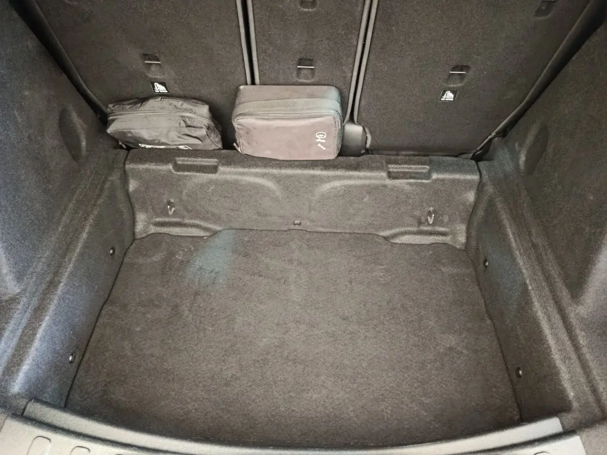 Coffre ouvert de MINI Countryman noir 2019, vue plongeante montrant un espace de rangement avec deux sacs noirs.