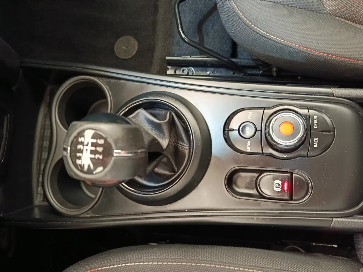 Vue rapprochée de la console centrale noire d’une MINI Countryman 2019 avec levier de vitesse manuel et commandes multimédia.