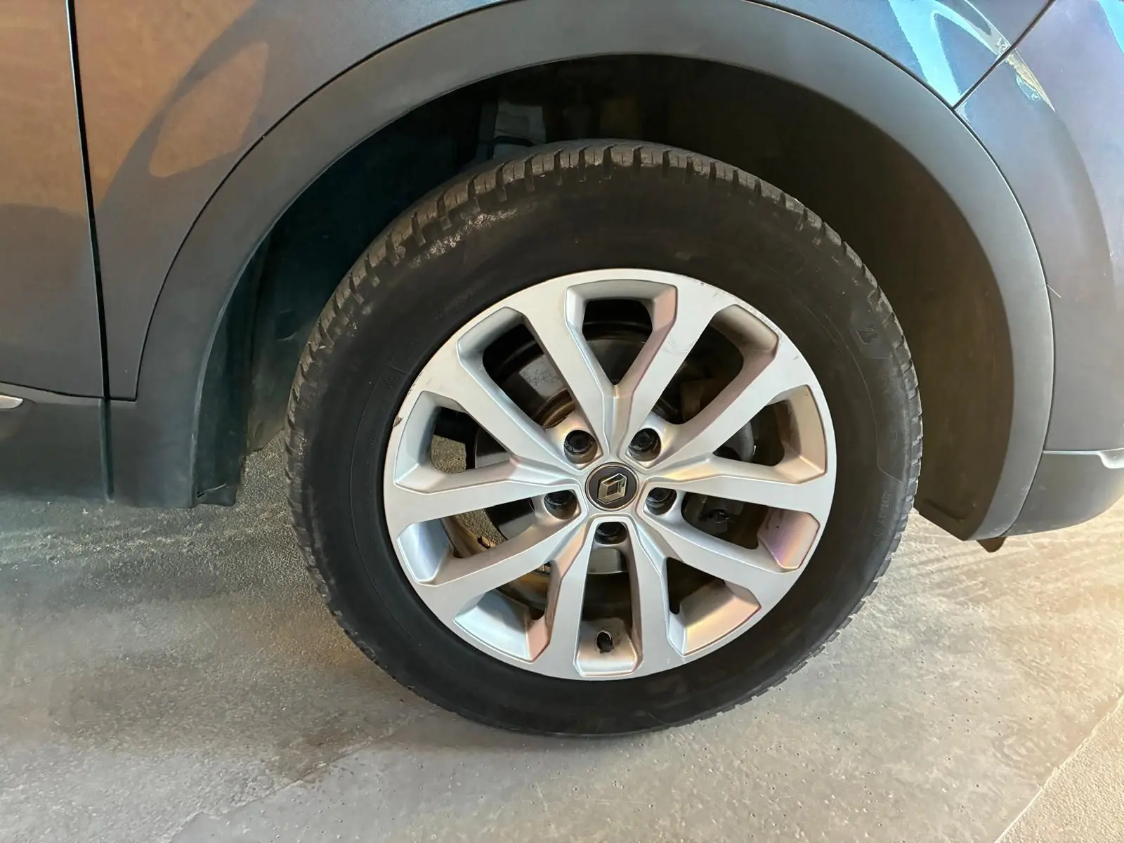 Gros plan sur la roue avant droite d’un Renault Kadjar gris 2019 avec jante alliage à plusieurs branches.