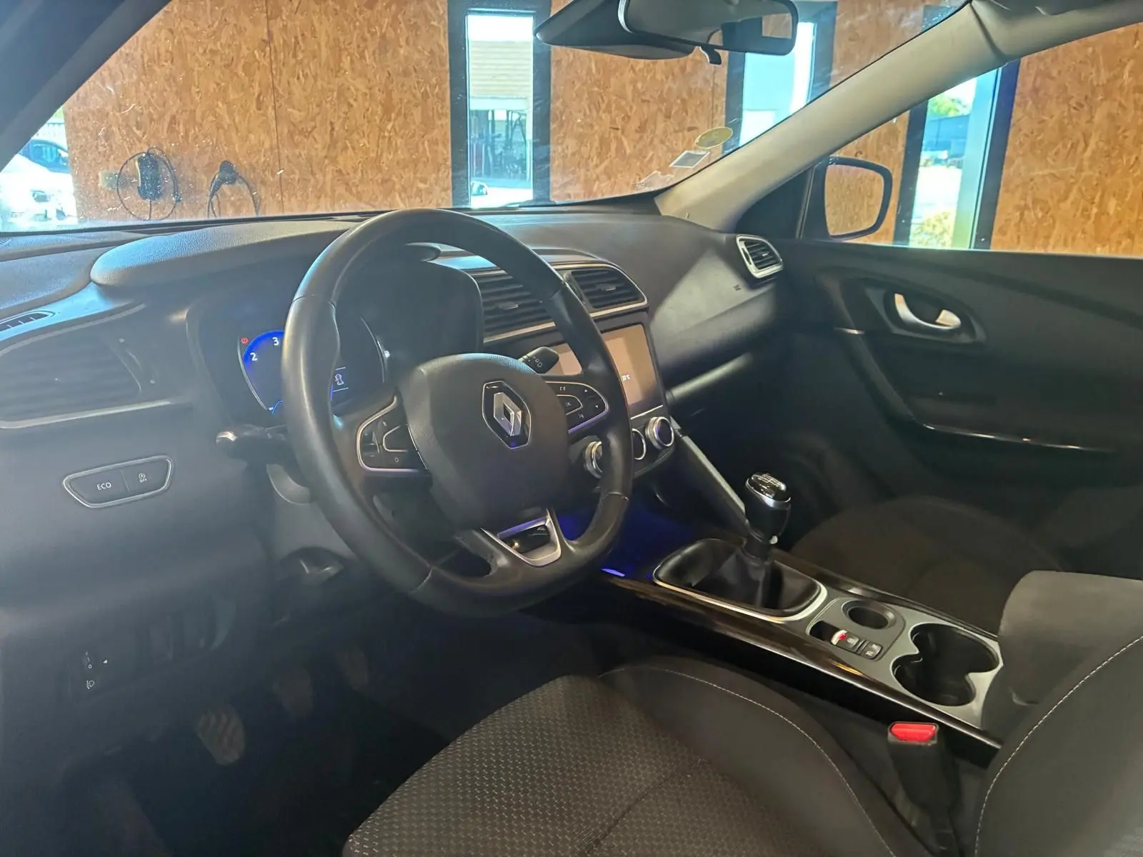 Vue intérieure côté conducteur du Renault Kadjar gris 2019, volant multifonction et boîte manuelle visibles.