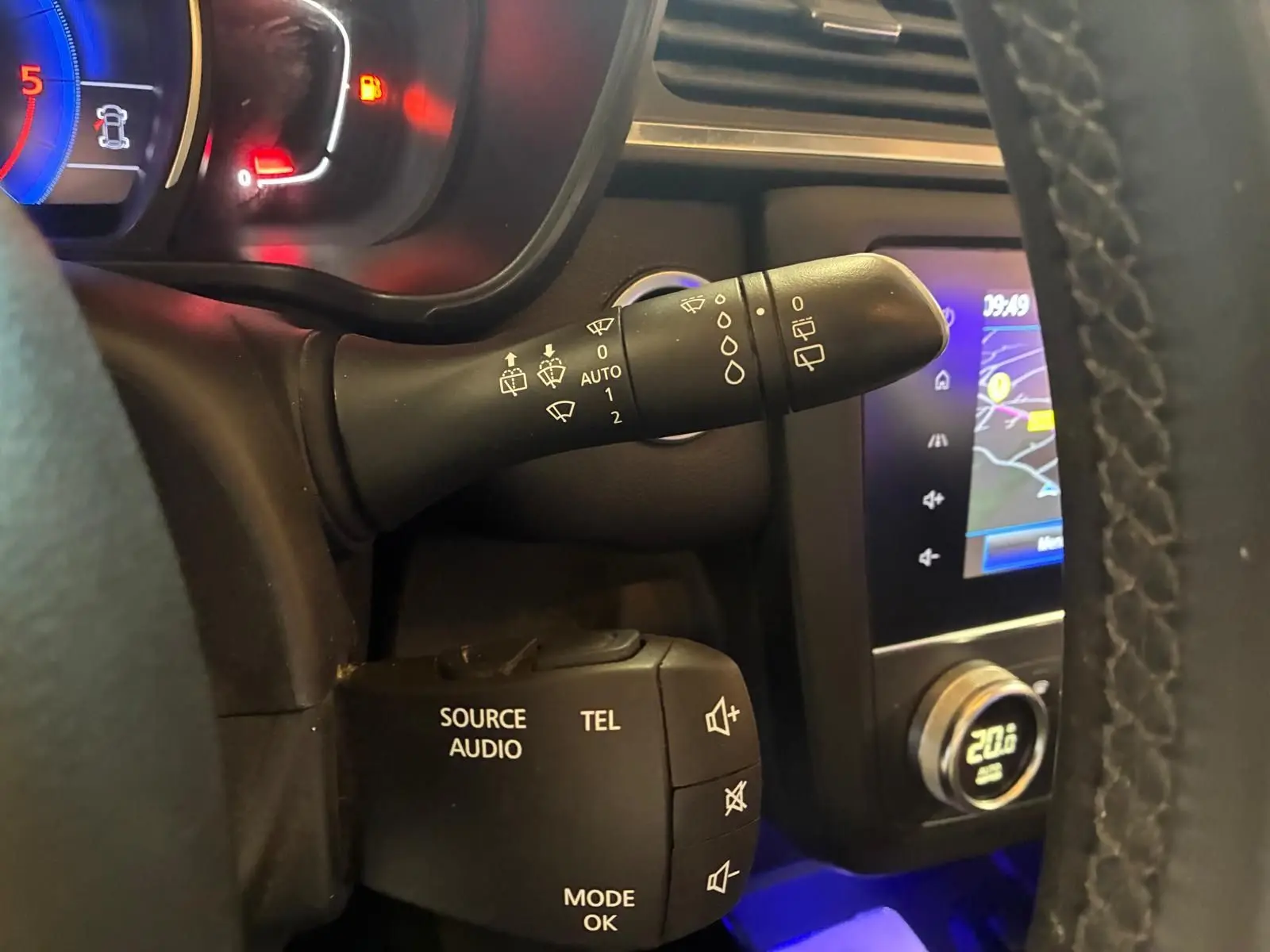 Vue rapprochée du volant côté gauche du Renault Kadjar gris 2019, montrant commandes audio et essuie-glace, avec écran GPS en arrière-plan.