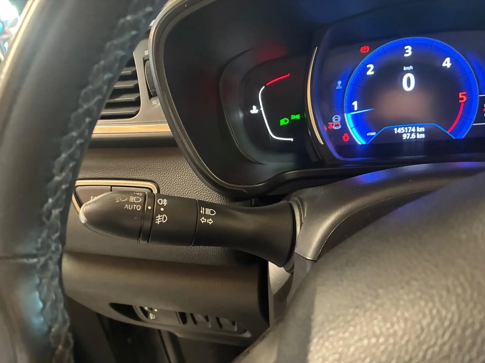 Vue rapprochée du tableau de bord côté gauche du Renault Kadjar gris, affichant le compteur digital et la commande des phares.
