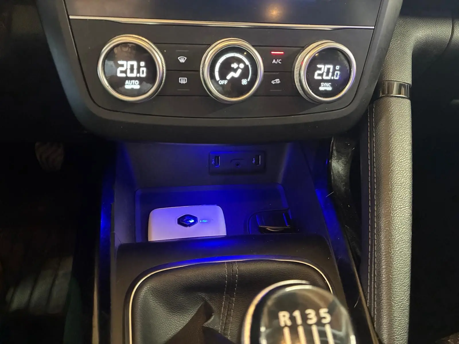 Gros plan sur la console centrale du Renault Kadjar gris, montrant la climatisation digitale et le levier de vitesse manuel.