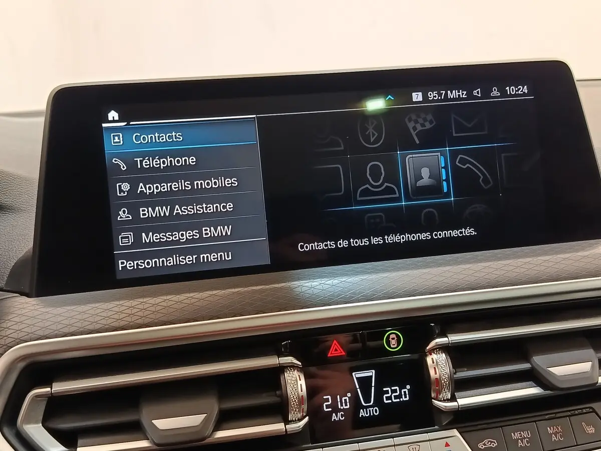 Écran tactile central intérieur du BMW X3 blanc 2023 affichant le menu contacts et options connectées.