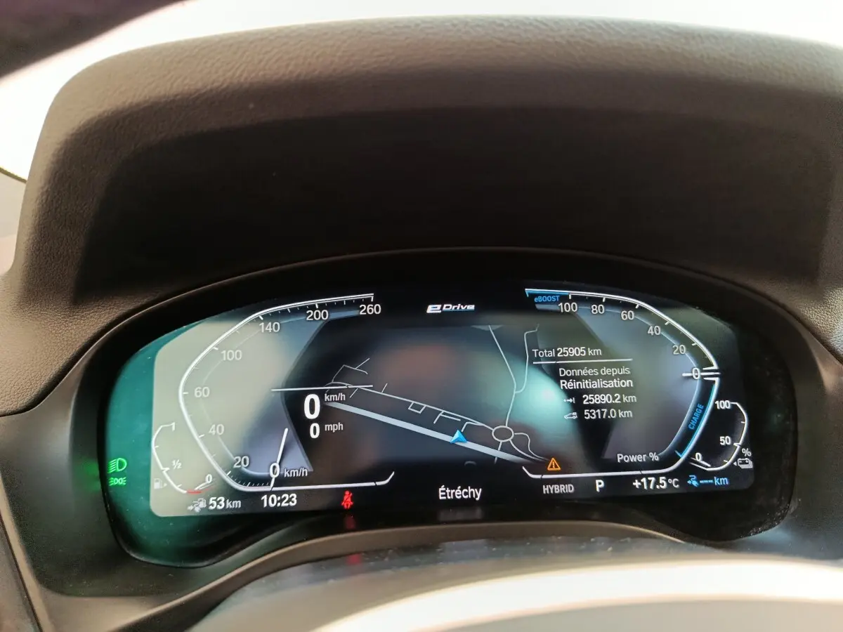 Tableau de bord numérique de BMW X3 blanc, affichage 12,3 pouces avec navigation et indicateurs hybrides.