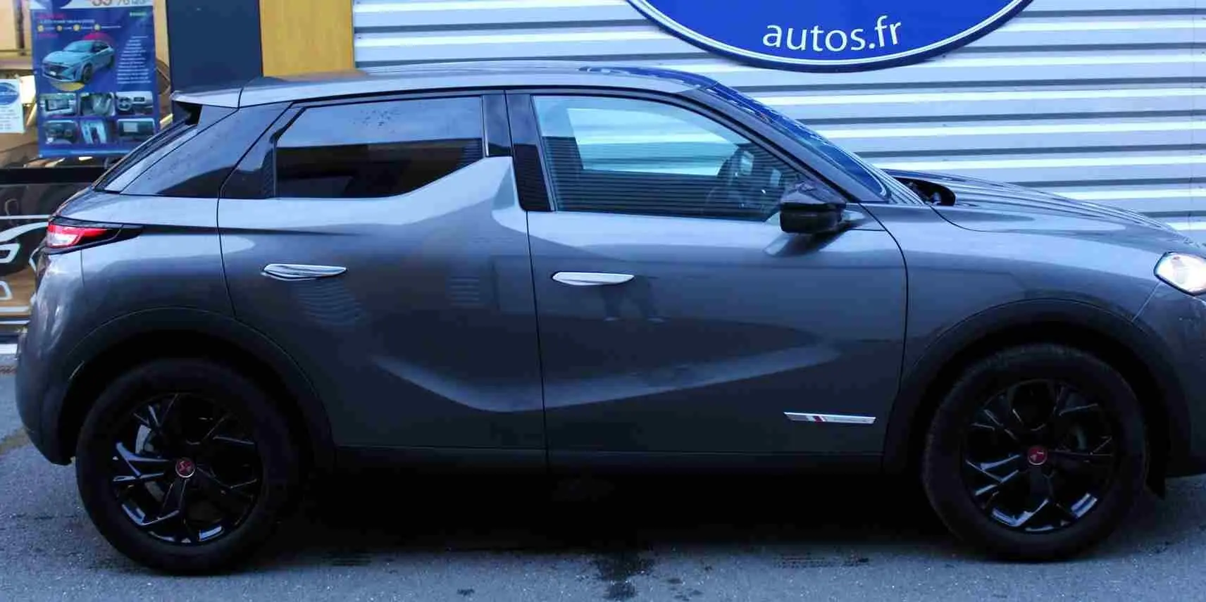 Vue de profil côté gauche d'un DS3 Crossback gris platinium métal avec jantes noires et lignes sculptées.