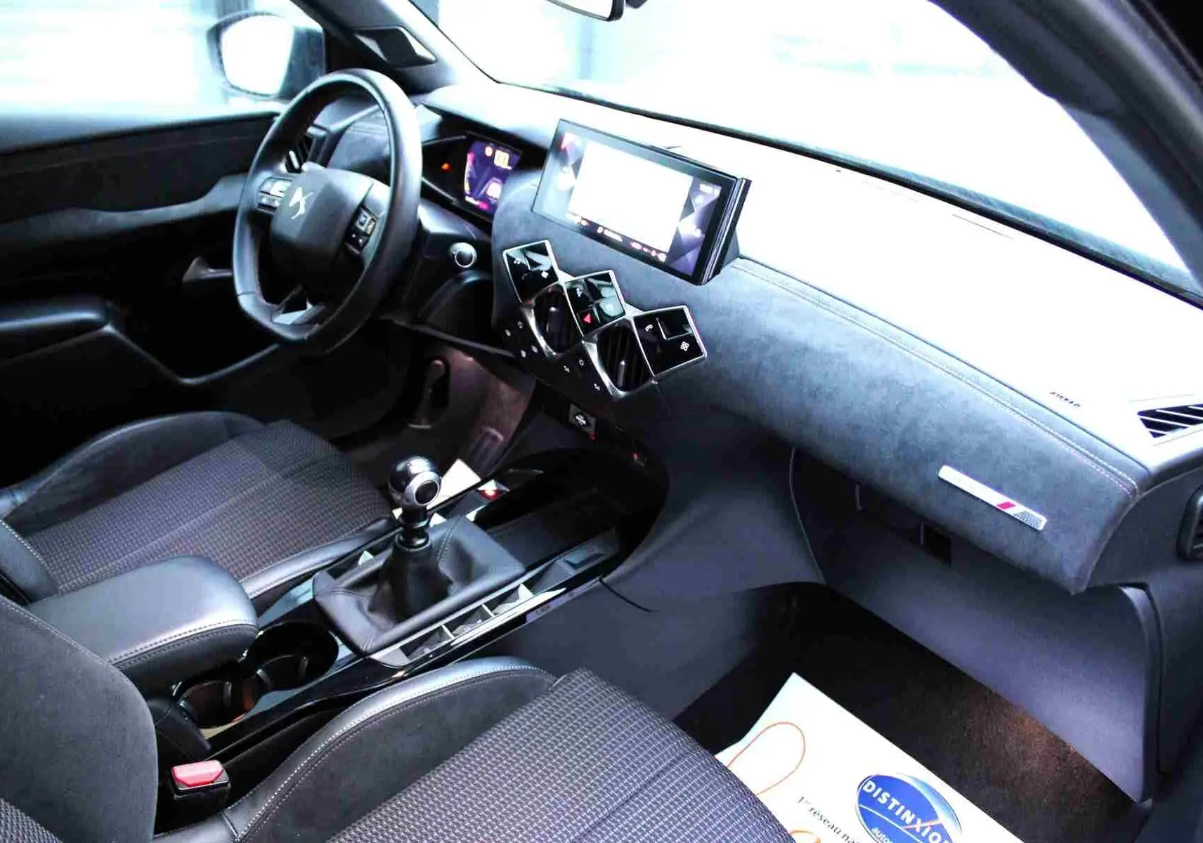 Vue intérieure côté conducteur du DS3 Crossback 2021 gris platinium, avec tableau de bord moderne et levier de vitesse manuel.