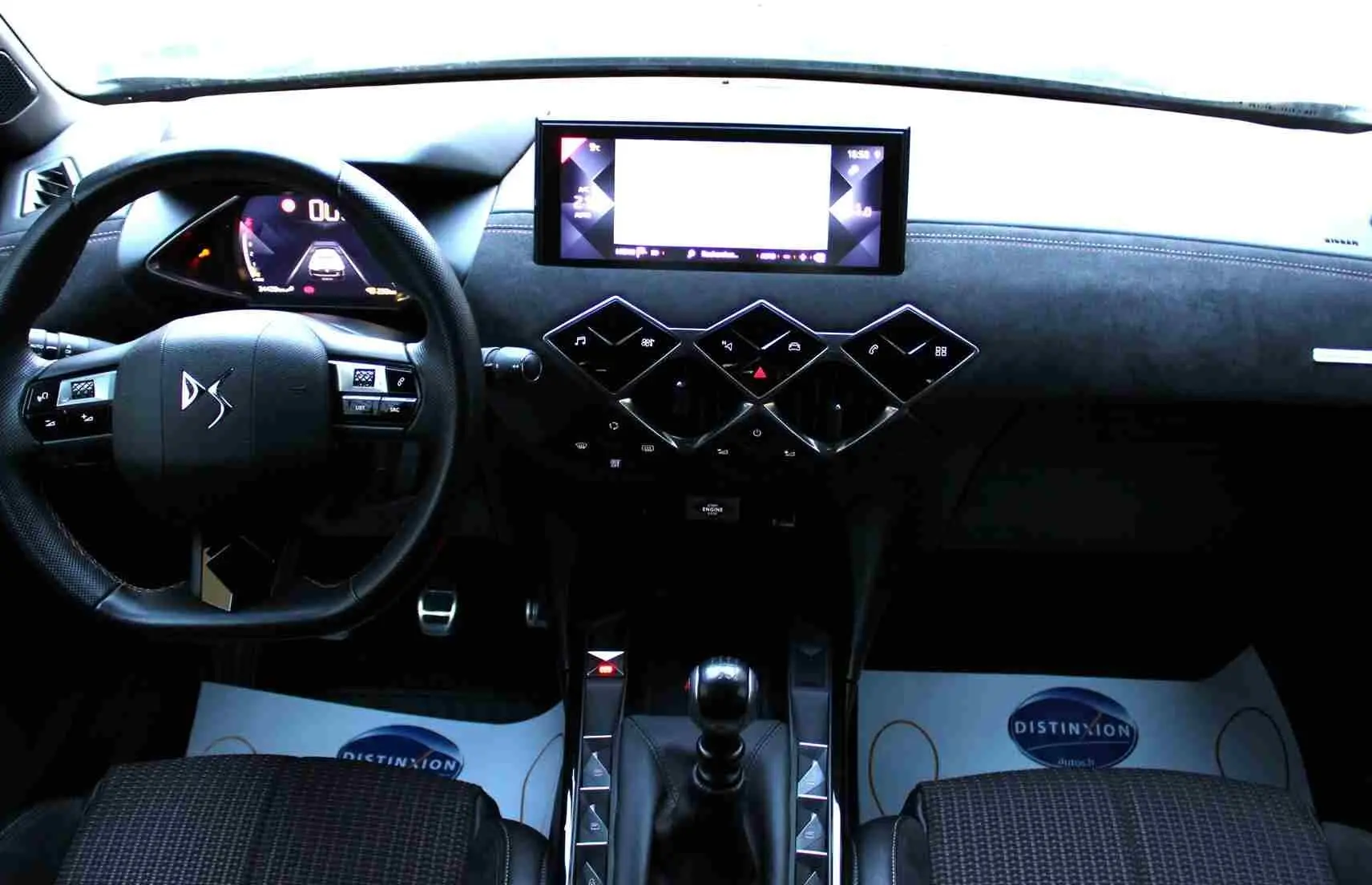 Vue intérieure frontale du tableau de bord et volant noir de la DS3 Crossback 2021 avec écran tactile et commandes en losange.