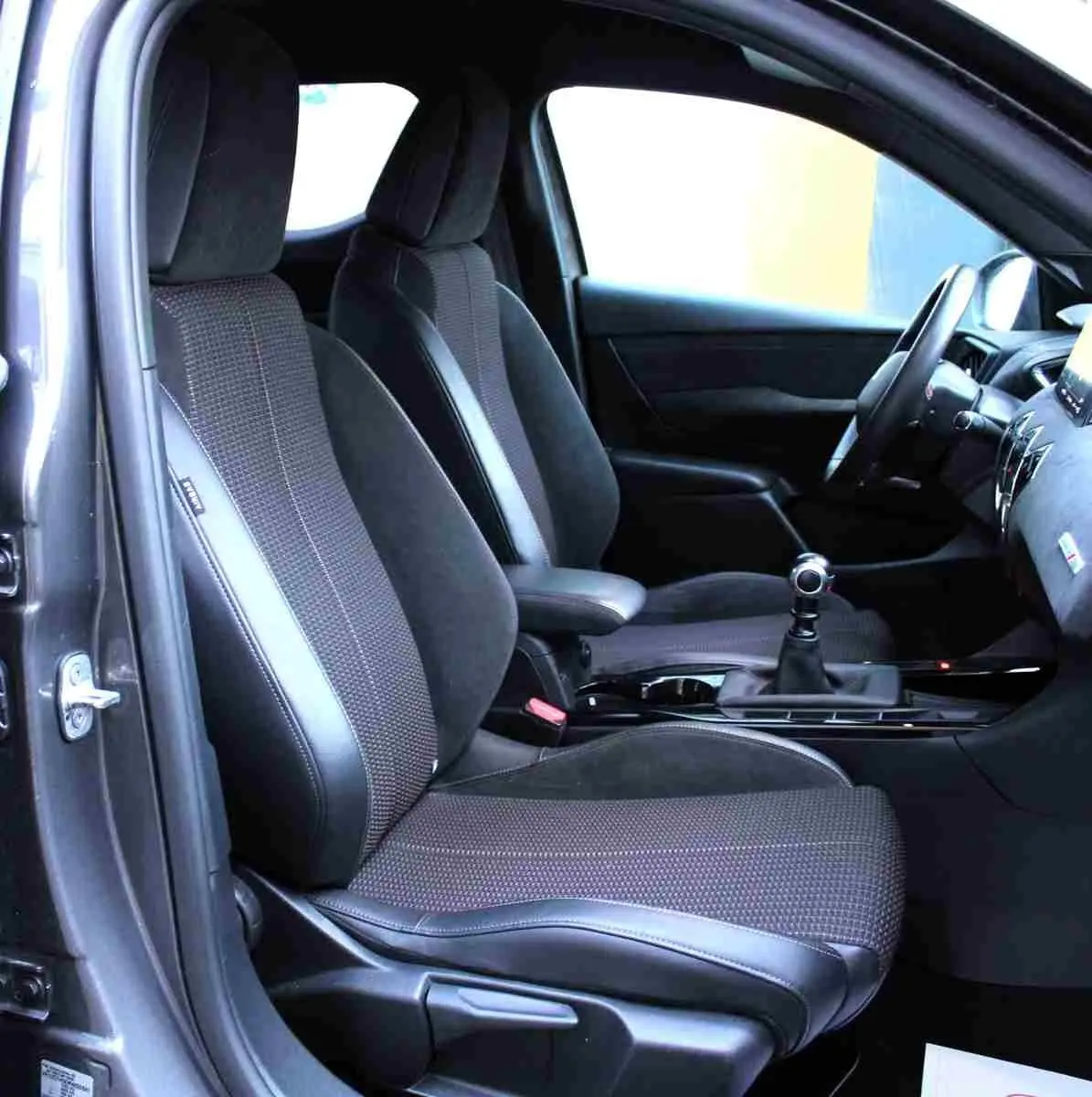 Vue intérieure côté conducteur du DS3 Crossback gris platinium, montrant les sièges en tissu et cuir noir avec levier de vitesse manuel.