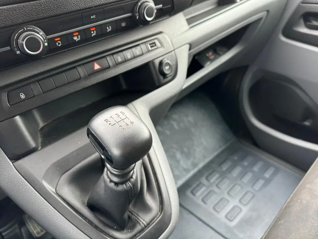 Gros plan sur le levier de vitesses manuel noir et la console centrale grise du Toyota Proace Fourgon blanc de 2021.