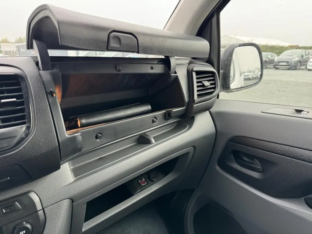 Intérieur côté passager du Toyota Proace Fourgon blanc 2021, avec boîte à gants ouverte et tableau de bord gris.