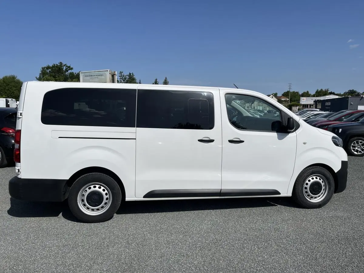 Profil côté gauche du Toyota Proace Fourgon blanc 2021 avec portes latérales coulissantes vitrées et jantes acier 16 pouces.