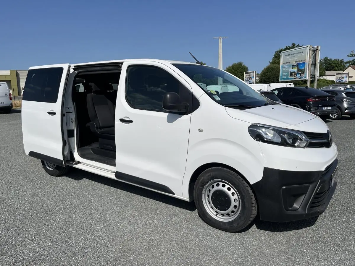 Toyota Proace Fourgon blanc vu en 3/4 avant droit avec porte latérale coulissante ouverte dévoilant l'intérieur.