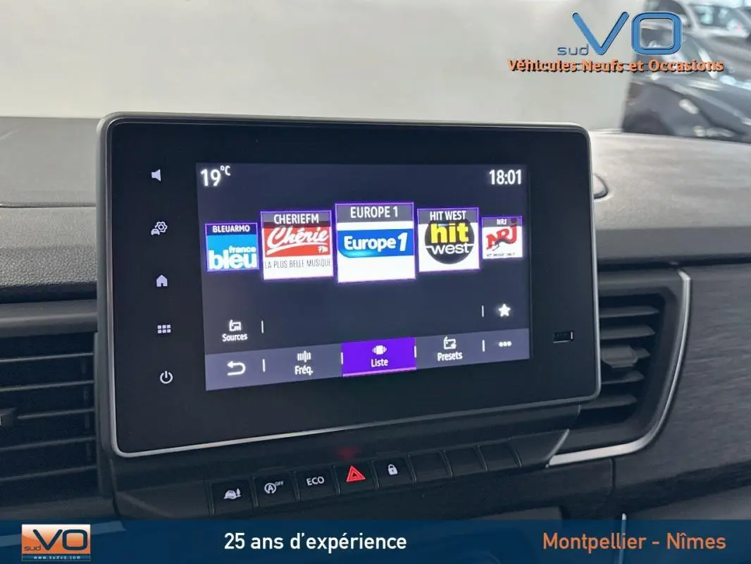 Écran tactile multimédia du Renault Trafic Fourgon gris 2025, affichant les stations radio avec commandes en dessous.