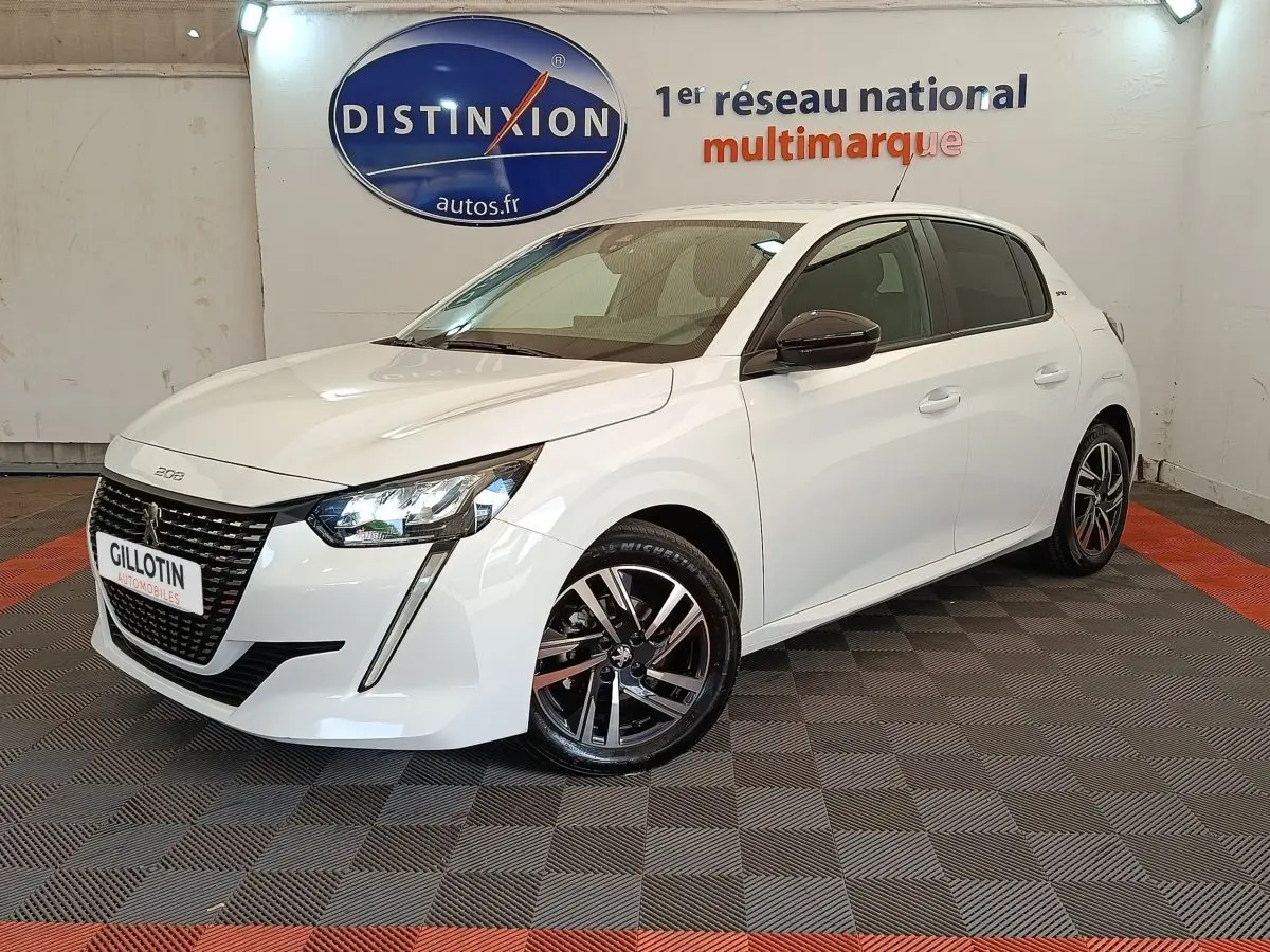Peugeot 208 PureTech 75 S&S Style blanc en 3/4 avant droit, avec jantes alliage et feux LED distinctifs.