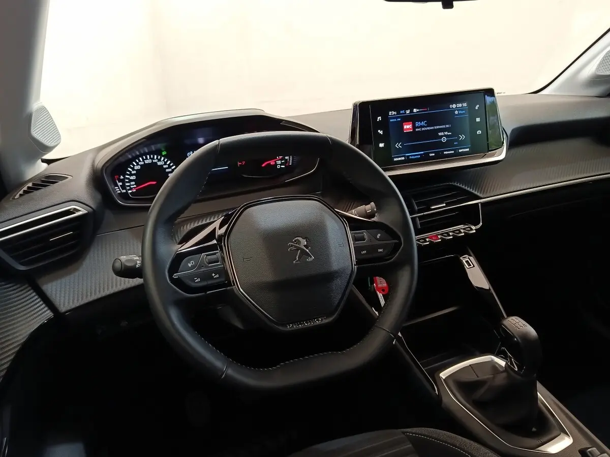 Vue intérieure centrée sur le volant cuir et tableau de bord numérique de la Peugeot 208 PureTech 75 S&S Style.