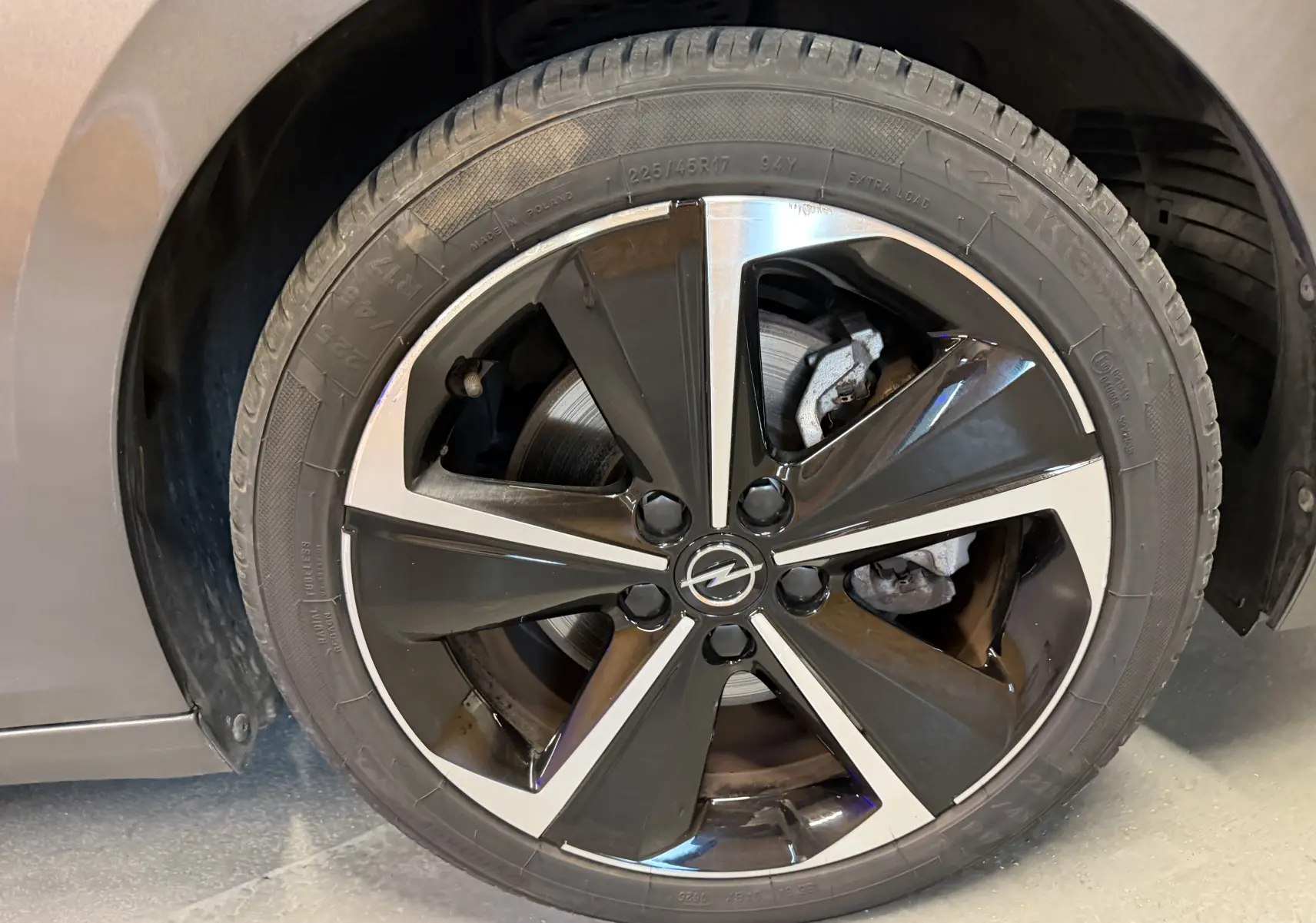 Gros plan sur la jante alliage 17'' Admiral diamantée noire et argentée de l'Opel Astra gris 2024.