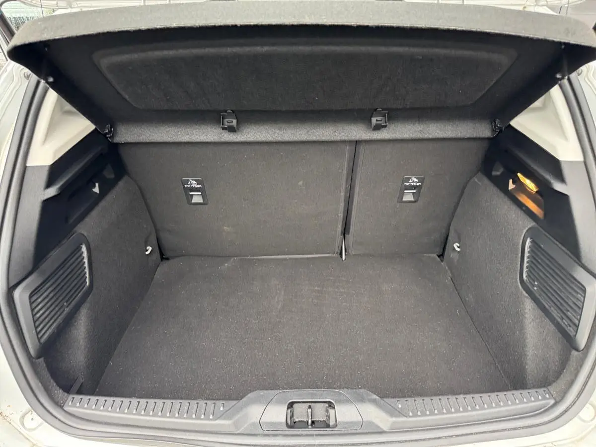 Coffre ouvert de Ford Focus gris 2021, vue intérieure arrière montrant un espace de chargement propre et bien agencé.