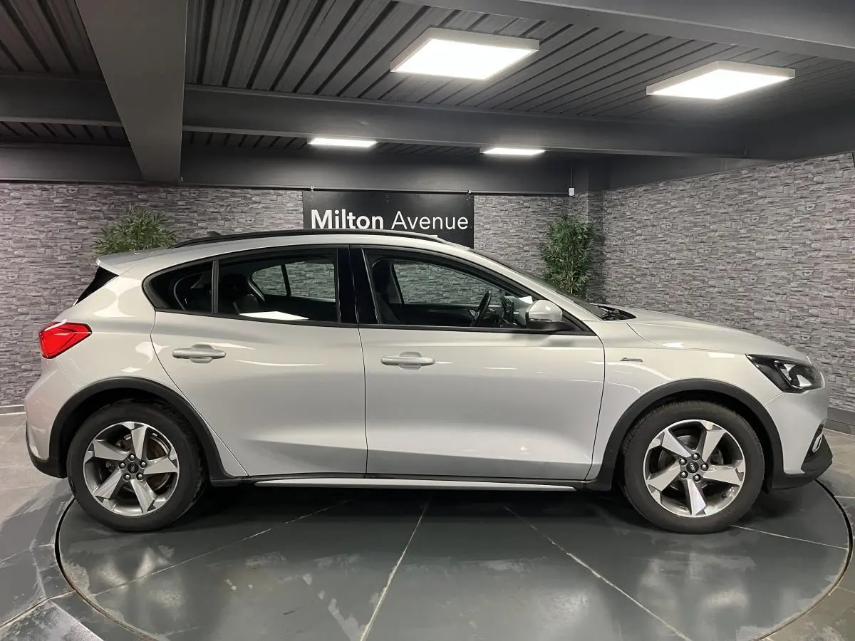 Profil côté gauche d'une Ford Focus gris lunaire 2021 avec jantes alliage 17 pouces et poignées couleur carrosserie.