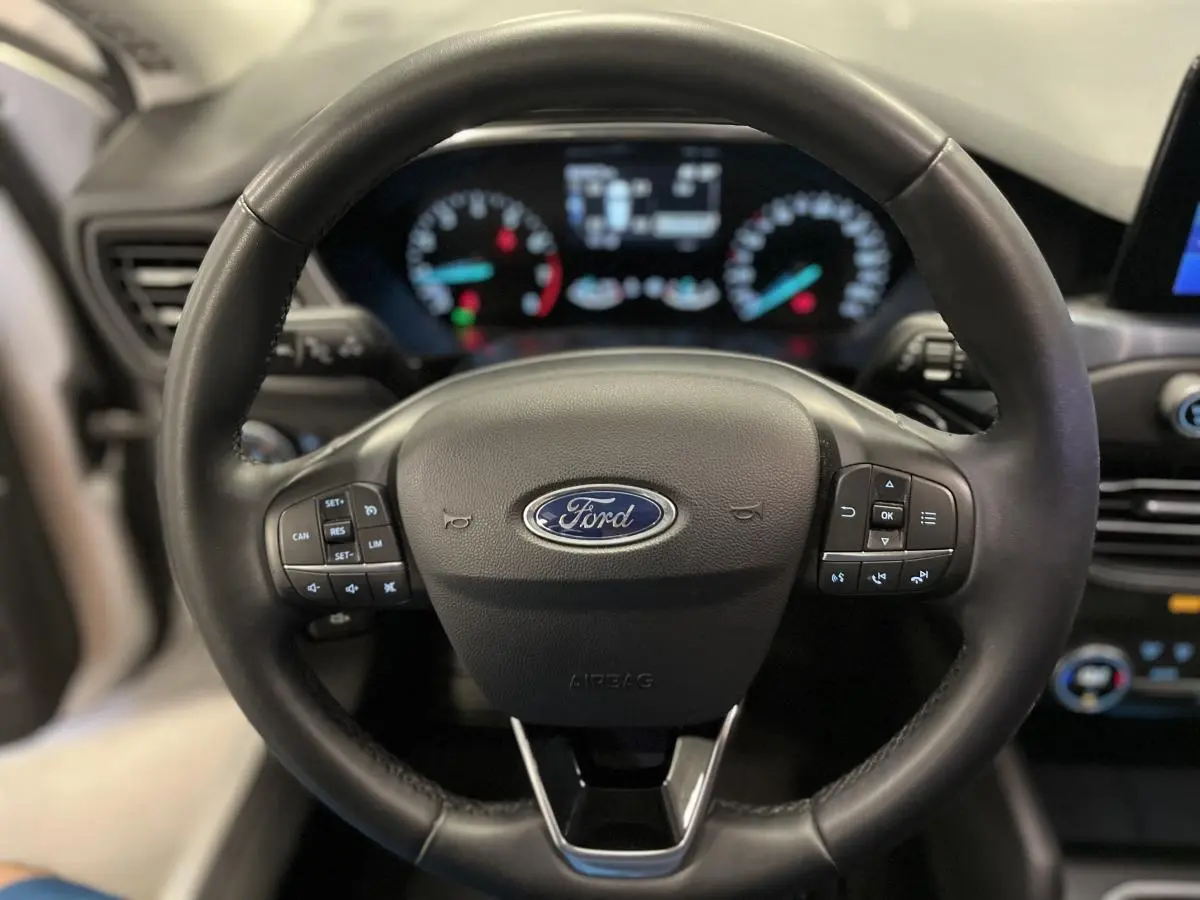 Volant cuir noir Ford Focus 2021 avec commandes intégrées, tableau de bord numérique flou en arrière-plan