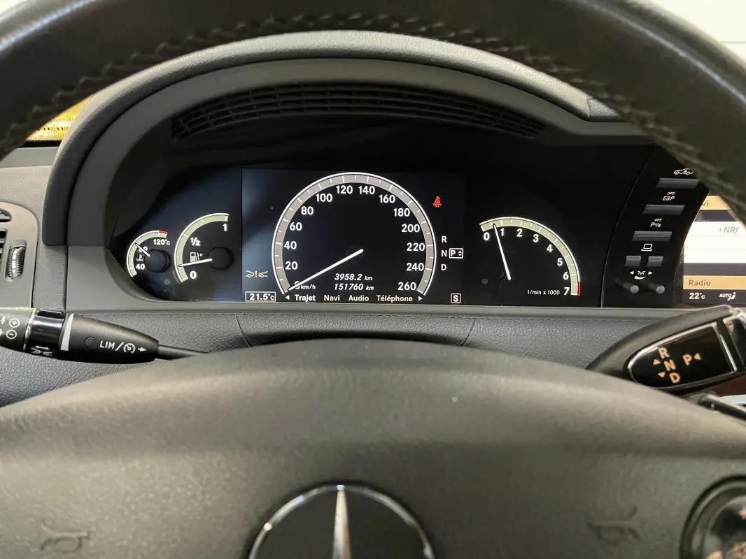 Vue intérieure du tableau de bord et volant multifonctions d'une Mercedes Classe CL 500 4-Matic noire de 2009.