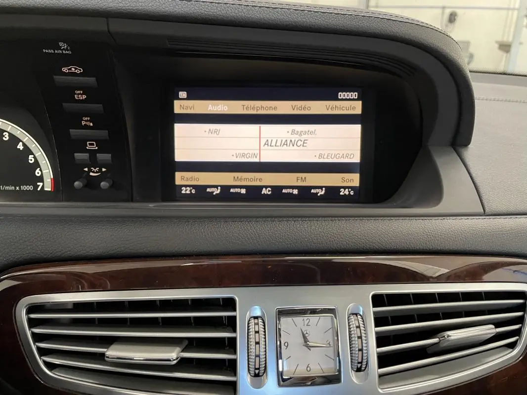 Tableau de bord de Mercedes Classe CL 500 4-Matic 2009, vue centrale avec écran multimédia et horloge analogique bois.