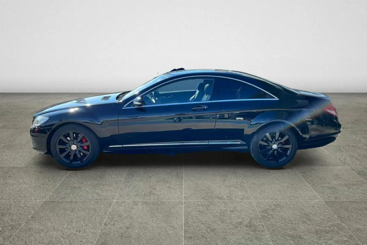 Profil côté gauche d'une Mercedes Classe CL 500 4-Matic noire avec jantes alliage noires et étriers rouges.