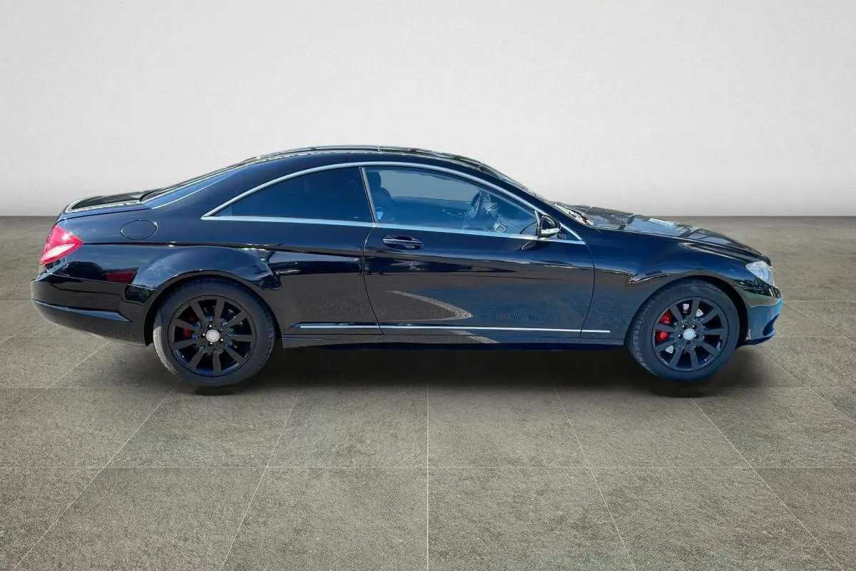 Profil côté gauche d'une Mercedes Classe CL 500 4-Matic noire avec jantes alliage noires et étriers rouges.