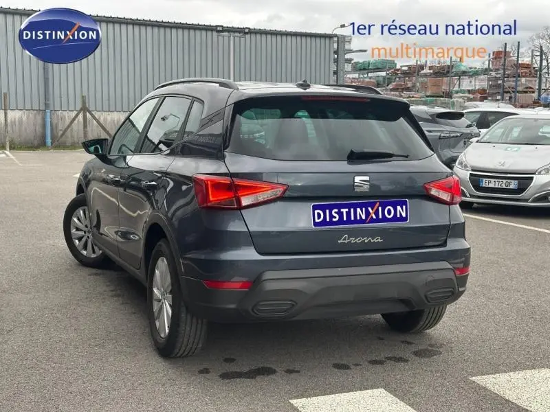 Vue 3/4 arrière droite du SEAT Arona 2025 en Gris Magnétique Métal avec toit noir, mettant en valeur ses feux arrière anguleux.