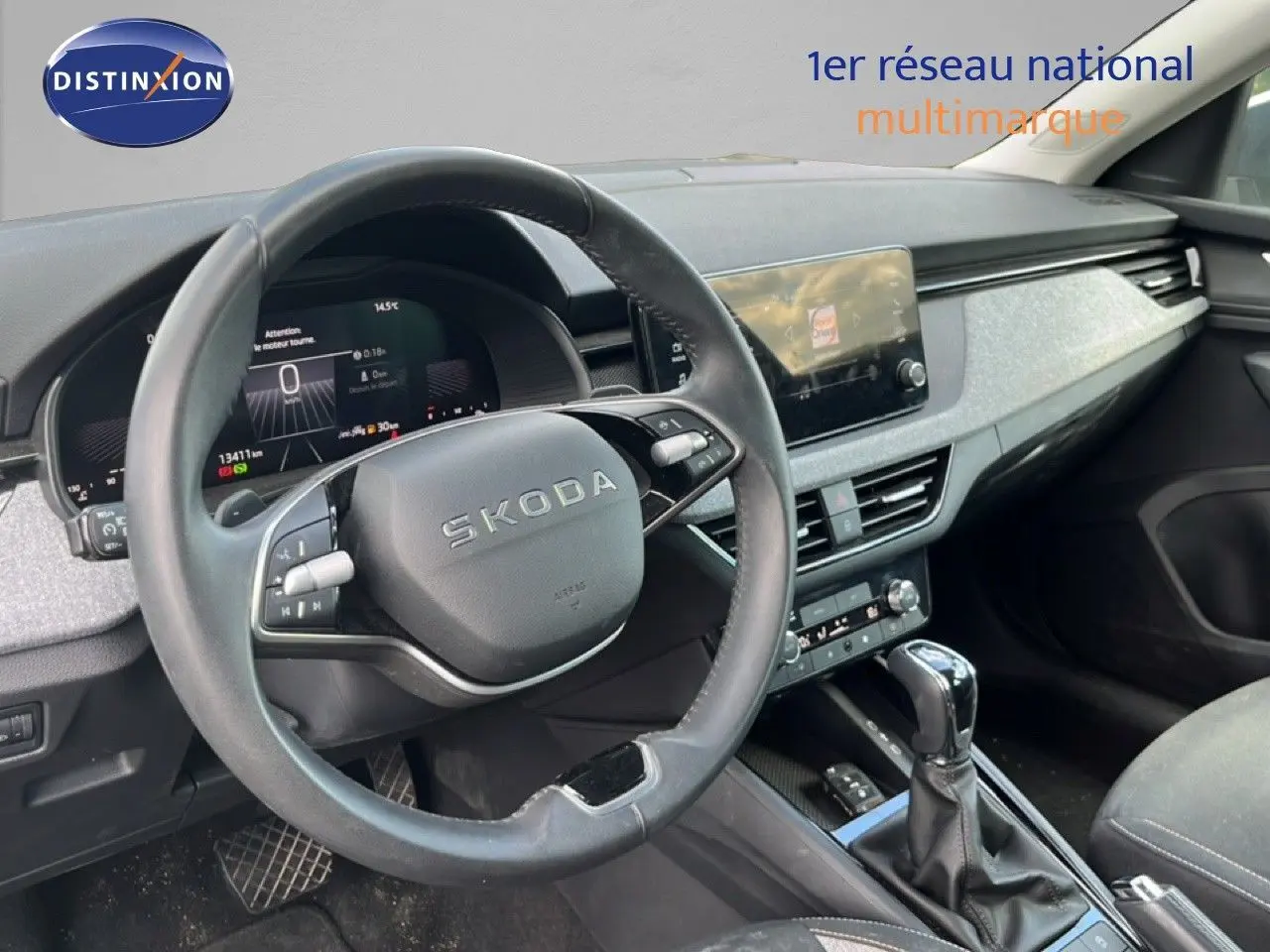 Vue intérieure du poste de conduite d'une Skoda Scala gris graphite, avec volant multifonction et écran tactile central.