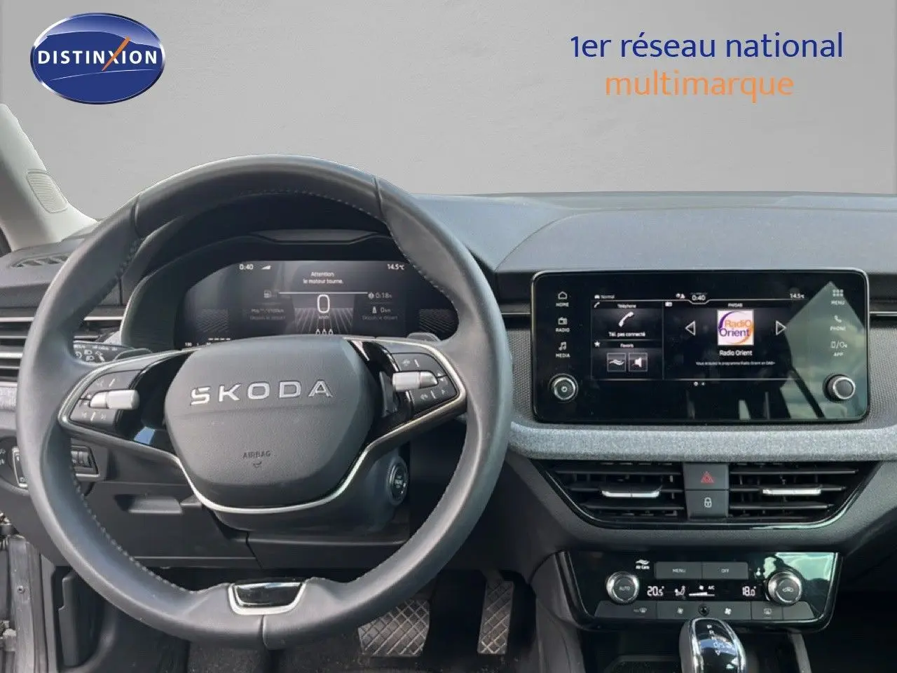 Vue intérieure centrée sur le volant SKODA et l'écran tactile du tableau de bord d'une SCALA gris graphite.