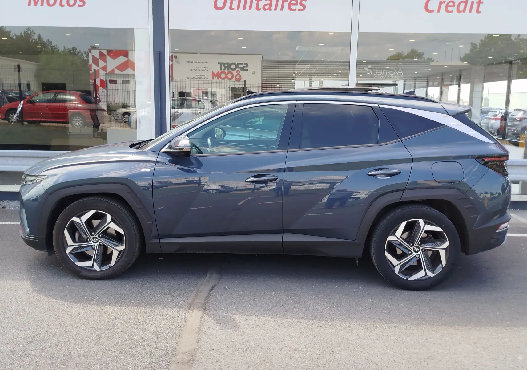 Vue de profil côté gauche du Hyundai Tucson 2021 en Teal Blue Métal avec jantes alliage distinctives.