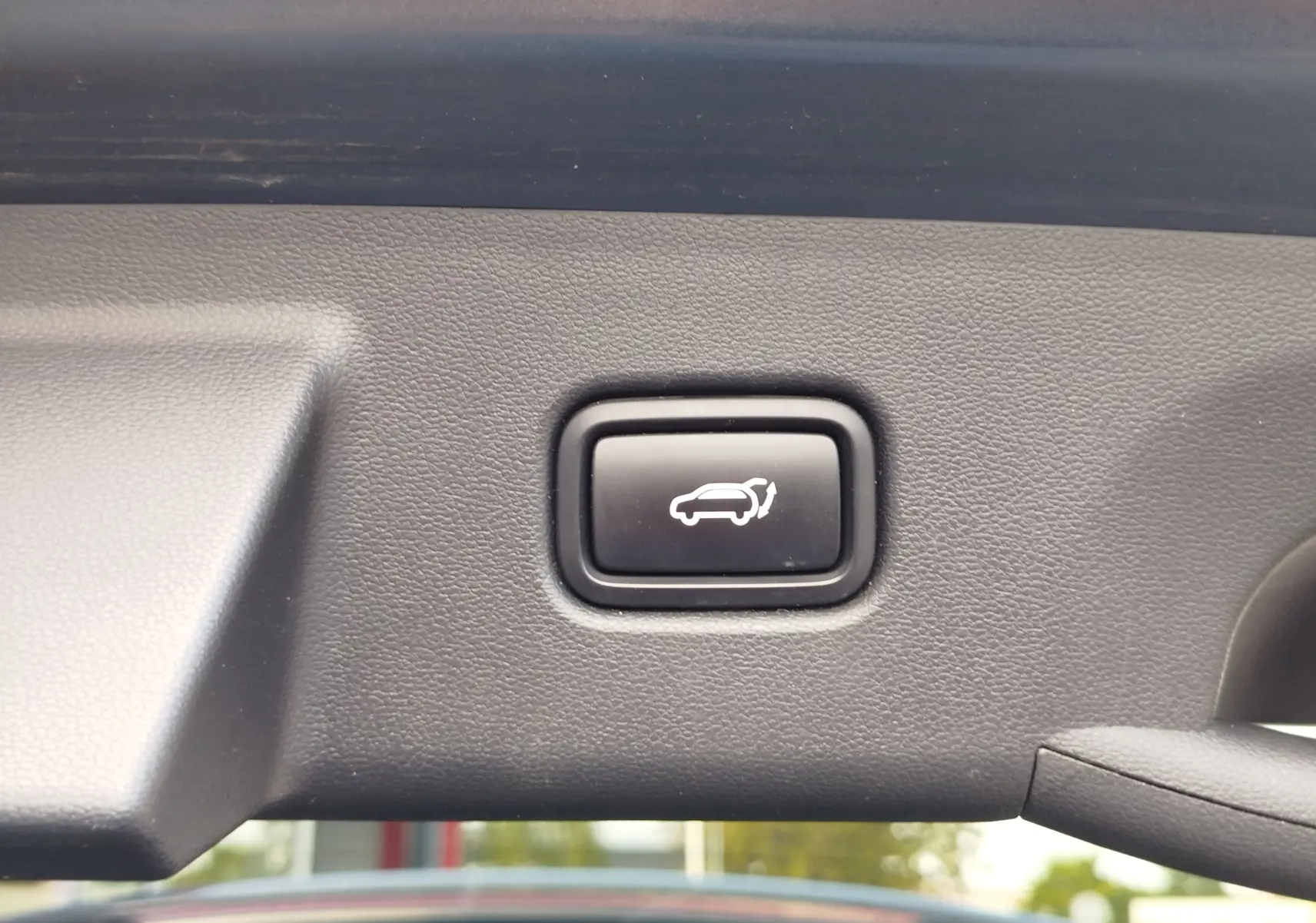Bouton d'ouverture électrique du hayon sur le panneau intérieur d'un Hyundai Tucson 2021 Teal Blue Métal.