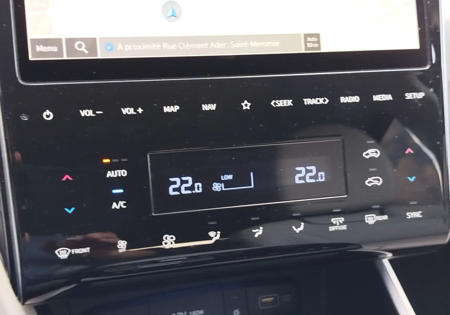 Détail de la console centrale du Hyundai Tucson 2021 en Teal Blue, affichant la climatisation automatique à 22°C.