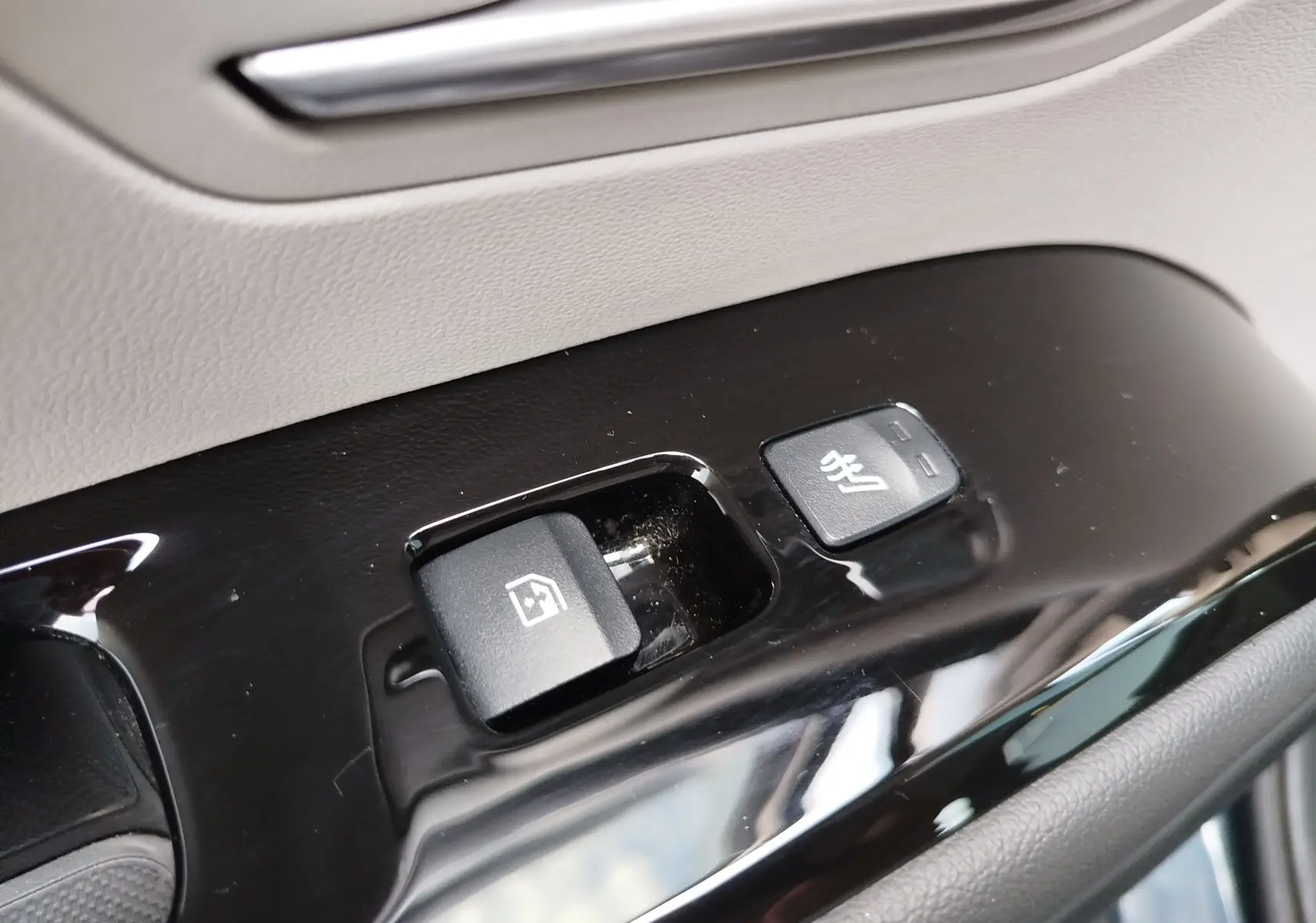 Gros plan sur les boutons de commande de la vitre et siège chauffant côté conducteur du Hyundai Tucson 2021 en Teal Blue Métal.