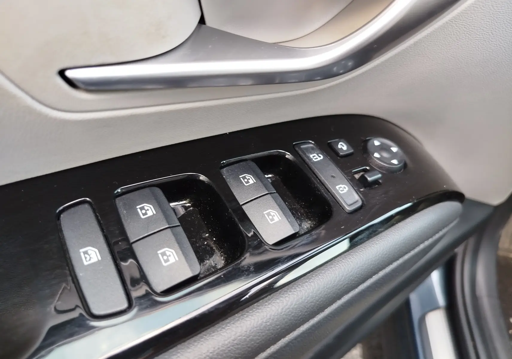Gros plan sur les commandes de lève-vitres et rétroviseurs côté conducteur du Hyundai Tucson 2021 en Teal Blue Métal.