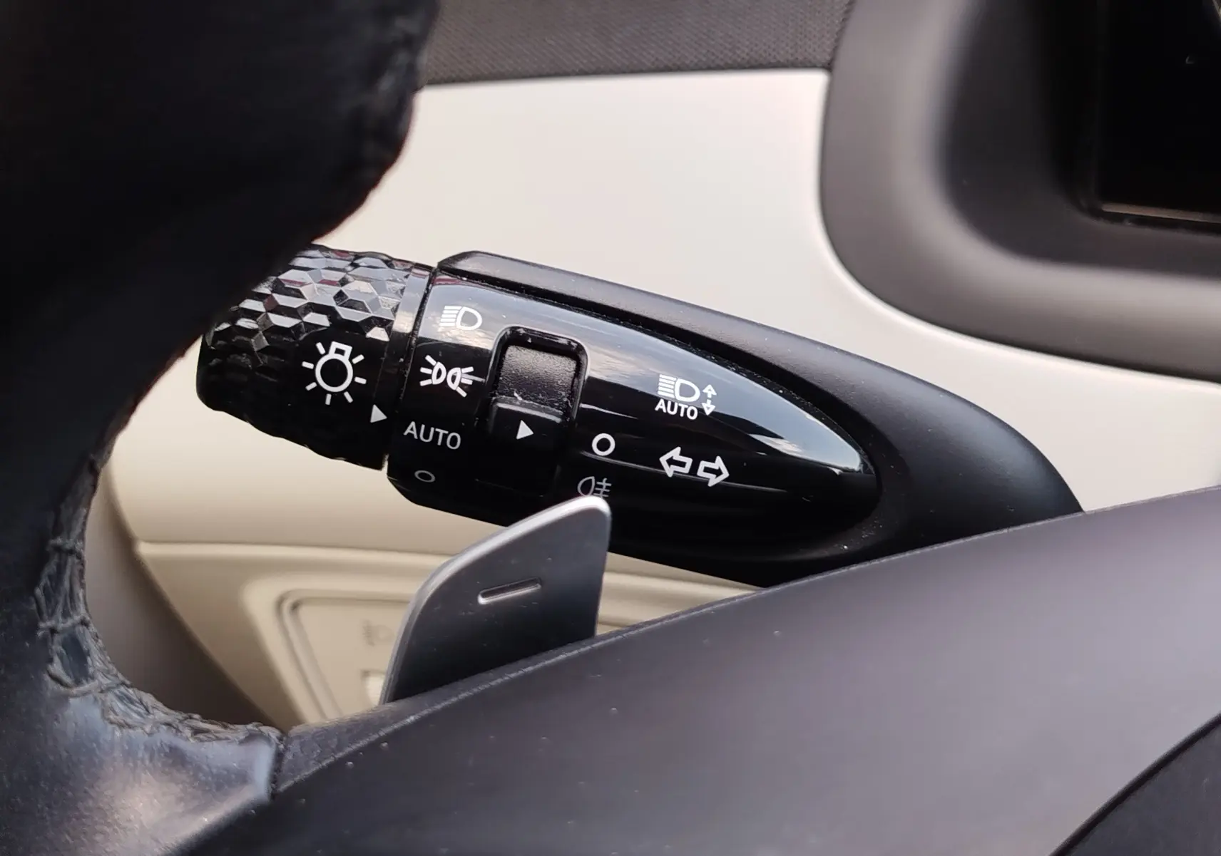 Gros plan sur la manette de commande d’éclairage à gauche du volant dans l’habitacle beige du Hyundai Tucson 2021.