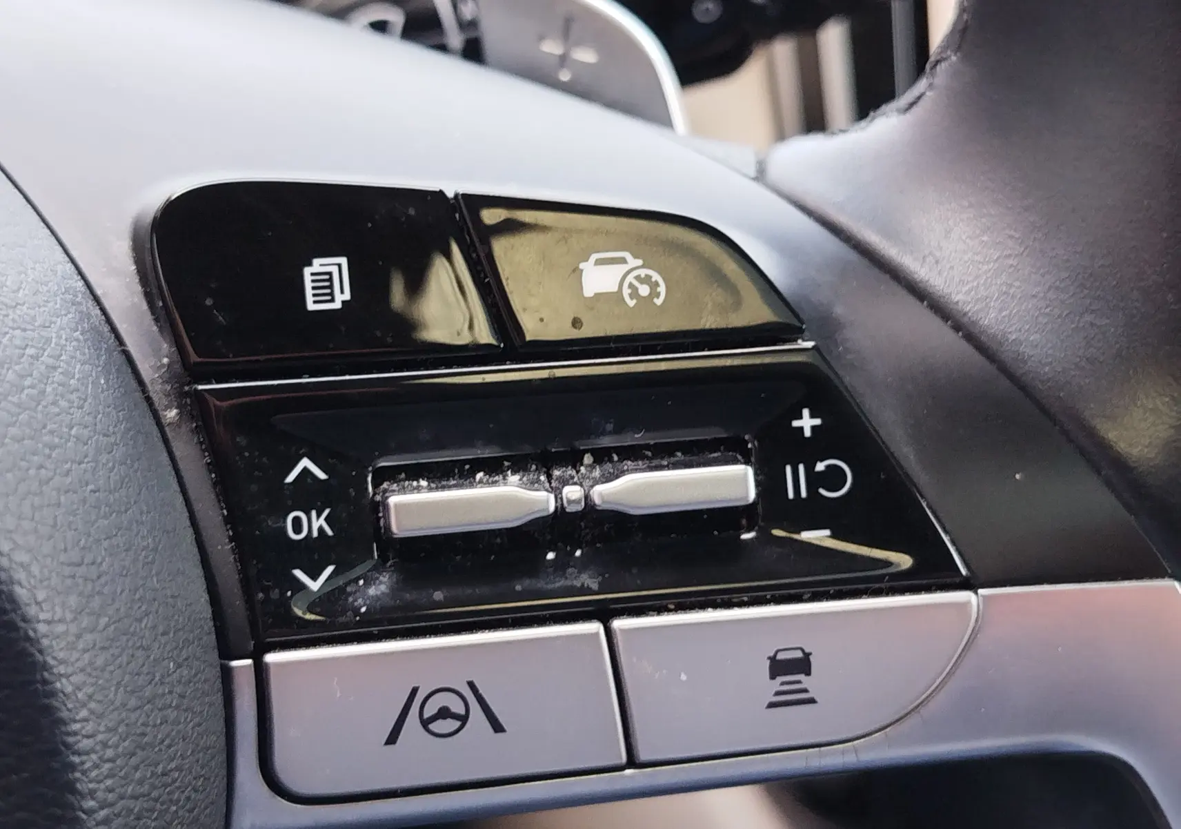 Gros plan sur les commandes au volant du Hyundai Tucson 2021, boutons noirs et argentés avec fonctions d'assistance à la conduite.