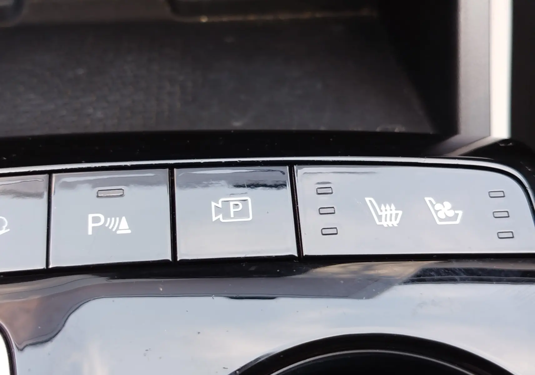 Gros plan sur les boutons de commande de confort et assistance du Hyundai Tucson 2021, finition Executive, intérieur noir brillant.